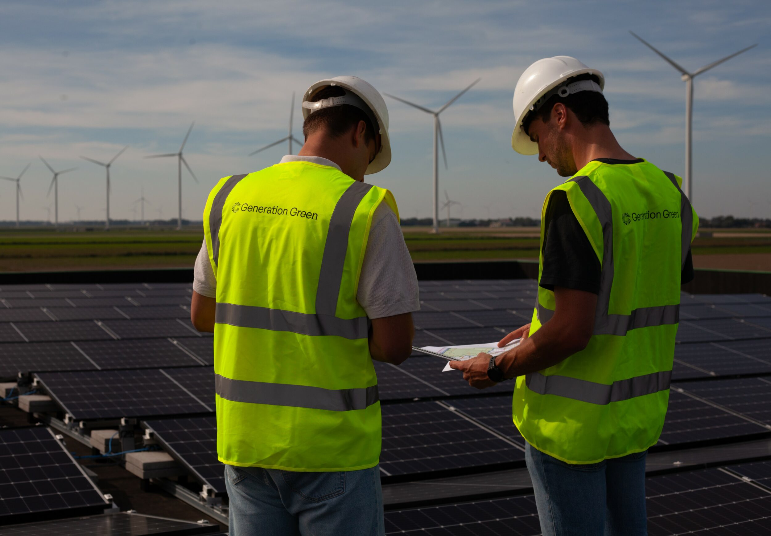 Medewerkers van Generation Green op het dak met zonnepanelen.