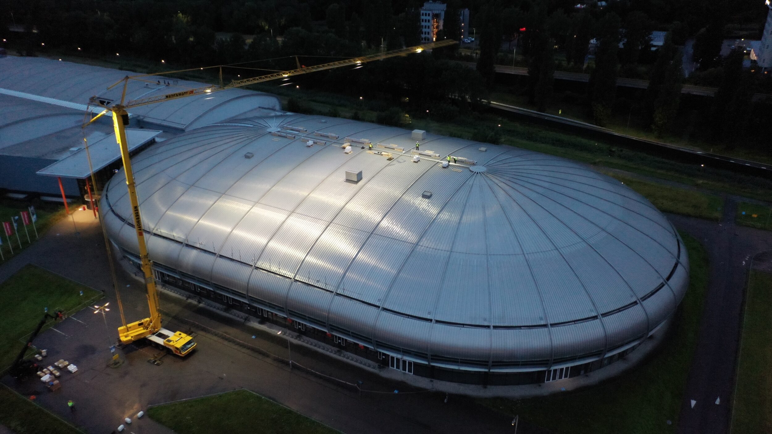 Installatie van zonnepanelen op het dak van optieport Sportboulevard in Dordrecht door middel van een kraan.